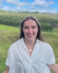 Portrait of Ella in front of trees and a blue sky 