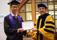 Undergraduate award winner accepting award from AMath Department Chair.